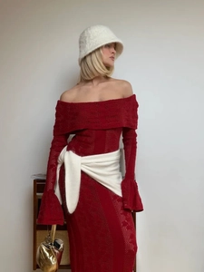 Close-up of the elegant red knit dress featuring intricate hollow-out floral textures