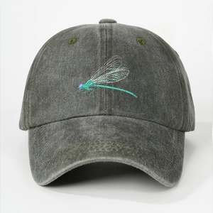 Close-up of dragonfly embroidery on a dark gray washed cotton baseball cap texture