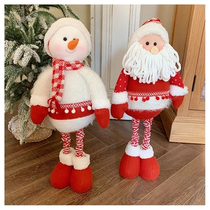 Detail of knitted plush Santa and Snowman dolls with telescopic legs on wooden floor