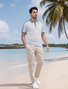Polo gris pour homme avec col contrasté sur une plage tropicale pour un look estival