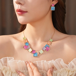 Detail of colorful square resin pendant necklace and earrings on a female model