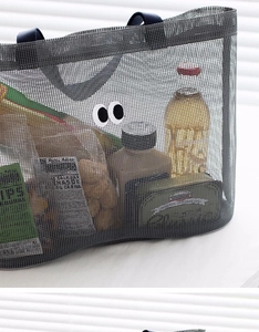 Detail of grey mesh tote with eye motif showing large capacity for snacks and drinks