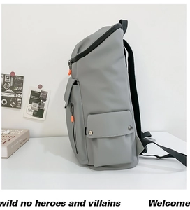Detail view of grey waterproof backpack with side pockets and vibrant orange zipper accents