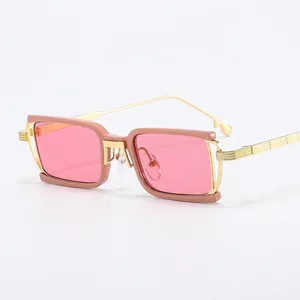 Retro rectangular sunglasses with pink lenses and gold hollow metal temples on white background