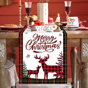 Christmas table runner with Merry Christmas lettering and red plaid elk on wooden table