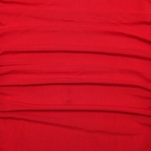 Detailed macro view of the red textured fabric with elegant horizontal pleats on the dress