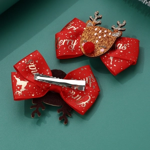 Detail of Christmas reindeer hair clips with red ribbon and gold glitter on green background