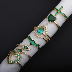 Detail of gold-plated rings with micro-set green and white zircon in various shapes