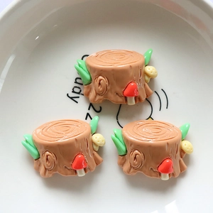 Macro detail of DIY resin tree stump miniatures with red mushrooms and green leaves
