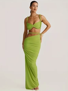 Detail of green halter top and ruched maxi skirt with woven rope ties and side slit
