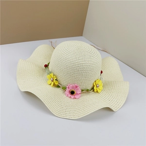 Detailed view of women's straw sun hat featuring wavy brim and colorful floral wreath