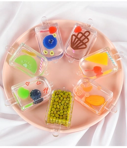 Close-up of assorted resin popsicle charms with realistic fruit slices on silk cloth
