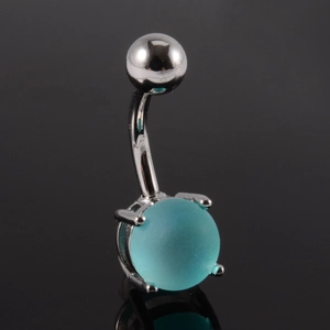 Gros plan du piercing de nombril avec perle turquoise et griffes en acier poli