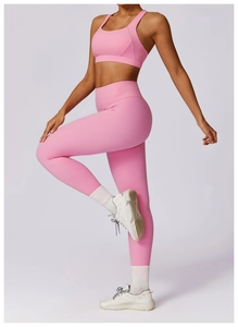 Detail view of pink high-waisted seamless yoga leggings and wide strap sports bra