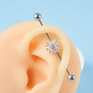 Close-up of stainless steel industrial piercing barbell with zircon flower on ear model