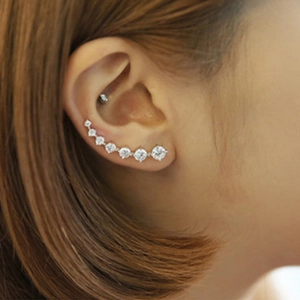 Close-up model view of silver earring row featuring seven gradient zircon stones