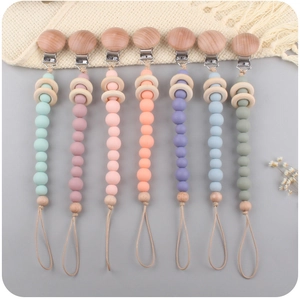 Flat lay of colorful silicone beaded pacifier clips with natural beech wood rings