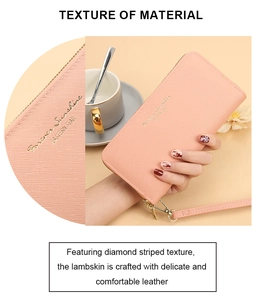 Detail of pink lambskin wallet showing diamond striped texture and golden logo tag