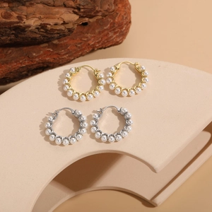 Detailed view of pearl beaded hoop earrings in gold and silver finish on display