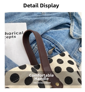 Close-up of canvas bucket bag with black polka dots and durable brown leather handle