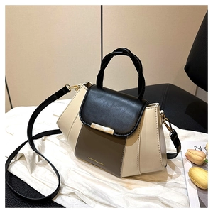 Close-up of color-block PU leather handbag with gold hardware and FASHION & BAGS logo