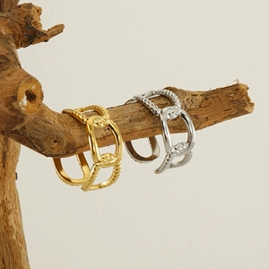 Detailed macro of gold and silver layered hollow chain ring on natural wood branch