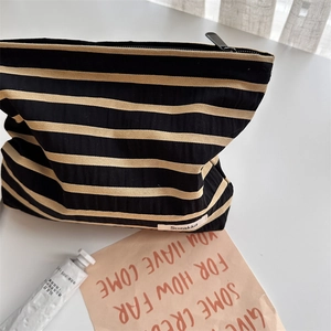 Detail of a large striped travel cosmetic bag with fabric texture and Sozakka label