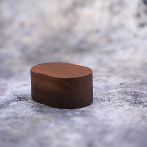Oval dark brown wood jewelry box with natural grain for ring and necklace storage