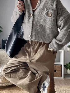 Close-up of grey knit cardigan with button details and casual styling for autumn