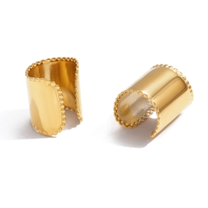 Golden wide ear cuffs with milgrain edges and polished finish on white background