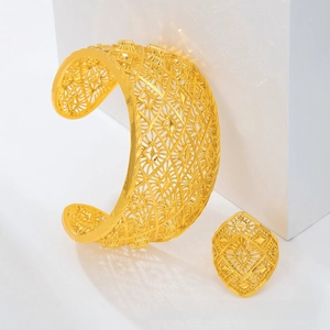 Detail of gold-plated hollow filigree bangle and ring set with geometric diamond patterns