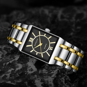 Macro detail of square quartz watch with black dial and silver gold stainless steel band