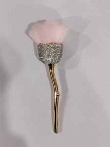 Detail of rose-shaped makeup brush with pink bristles and crystal-encrusted silver base