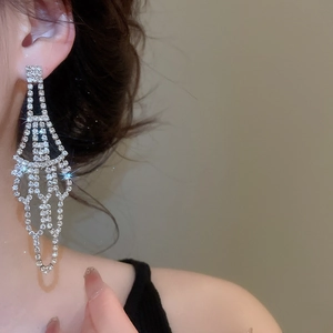 Close-up of model wearing silver long tassel drop earrings with sparkling rhinestones