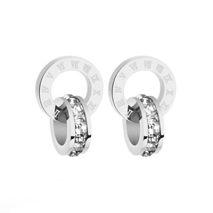 Gros plan de boucles d'oreilles argentées à deux cercles avec chiffres romains et cristaux
