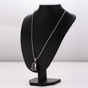 Detailed shot of bell pendant with 'Ride to Live' engraving on a black mannequin