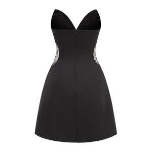Detail of V-neckline with crystal embellishments and side lace patchwork on black dress