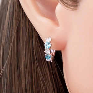 Silver hoop earrings featuring heart-shaped cubic zirconia in white and light blue