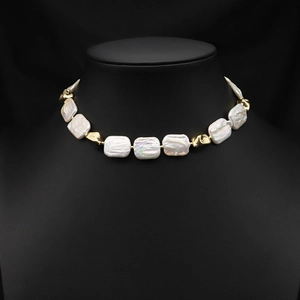 Baroque irregular pearl necklace with gold metal beads displayed on a black bust