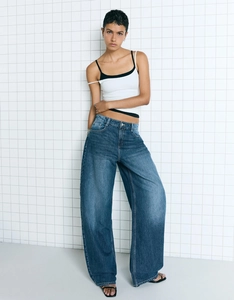 Close-up of blue high-waisted wide-leg jeans with vintage wash and denim texture details