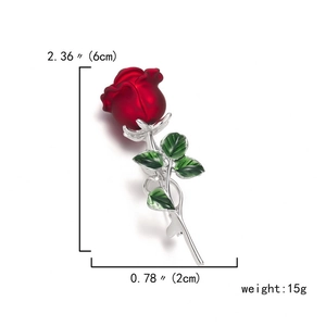 Detailed view of 6cm red rose brooch with green enamel leaves and silver stems