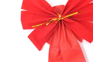 Detail of red velvet Christmas bow with gold wire tie for gift wrap and tree decor