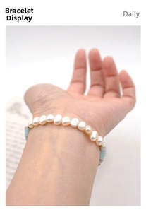 Detail of freshwater pearl and blue bead bracelet with gold accents on wrist
