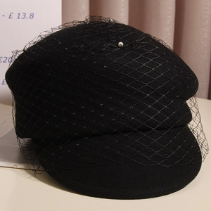 Elegant black wool newsboy cap with delicate pearl mesh veil in a vintage British style