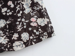 Detail of floral chiffon fabric with blue and pink flowers on a black background