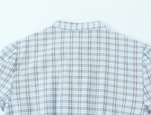 Detail of light blue plaid shirt fabric with breathable cotton-linen texture and stitching