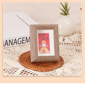 Minimalist wooden photo frame with success wish card on a rustic home desk setting