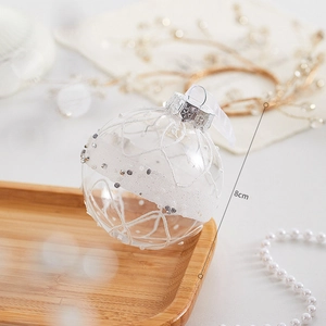 Détail d'une boule de Noël en verre de 8cm avec paillettes blanches et argentées