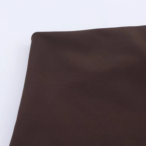 Detailed macro view of dark coffee brown ribbed knit fabric showing texture and stitching