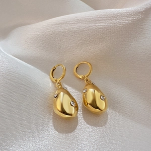 Elegant gold drop earrings with irregular waterdrop zircon pendants on white silk